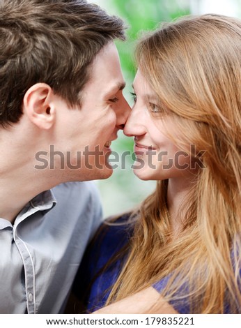 Very attractive young couple flirting on a sofa in living-room