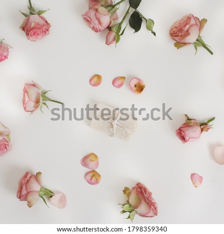 Natural handmade soap bars with flowers on white background. Homemade organic soap with pink roses and petals. Spa concept, body care products. Top view, flatlay closeup photo