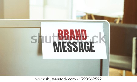 Sticky note on the computer. Text BRAND MESSAGE