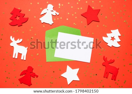 Christmas or New Year's composition 2021. Top view xmas decorative red paper background with wooden toys and copy space. Greeting card mockup. Flat lay.