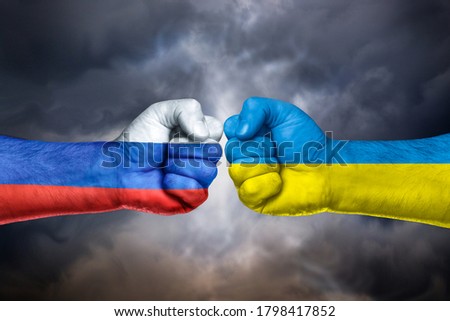 Flags of  Russia and Ukraine painted on two fists on sky.  Russia versus  Ukraine trade war disputes concept. Sanctions policy  Royalty-Free Stock Photo #1798417852