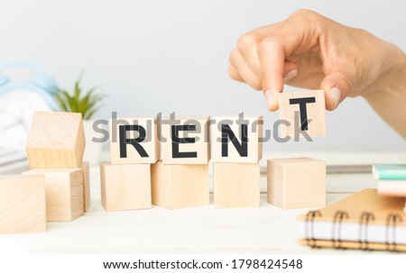 Concept word RENT on wooden cubes on a light background