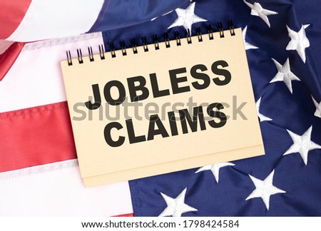 Male hand writing jobless claims on white note. Business concept. Royalty-Free Stock Photo #1798424584