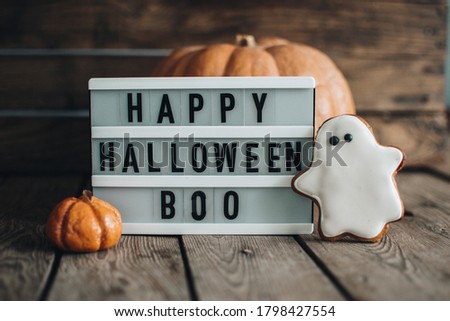Halloween holiday concept. Pumpkin. Autumn mood. Happy Halloween. White lightbox on the wooden table with autumn background. Halloween cookies. 