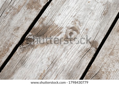 Angled photo of a board with a small knot on a wooden pier