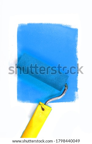 Painting a rough wall with roller. Paint roller leaving stroke of blue color over a white background. usable for text and messages.
