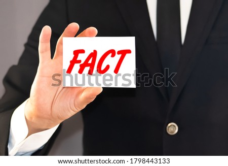 ManBusiness card with the word facts in the hand of a businessman.y People Holding the Red Word Facts