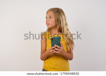Copyspace photo of charming Little girl with beautiful blonde hair over white background  stupor with something occurring in social media 