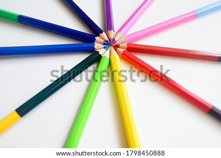 The cropped shot view of sharpened pencils of various lengths with a sharpener and pencil shavings on white background, blank copy space screen for your text message or information content.