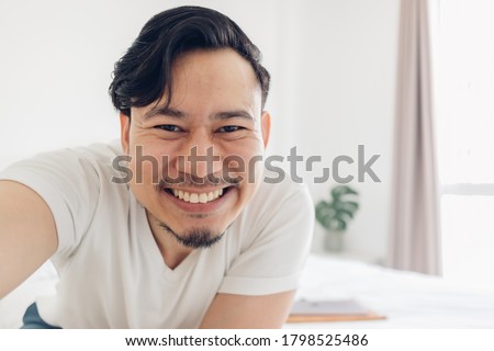 Innocences smile of happy Asian man take selfie photo of himself.