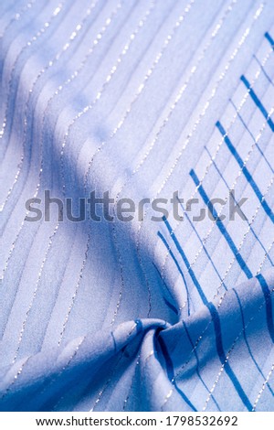 Texture background design, blue fabric with azure and white stripes of lurex, perfect for a fresh and comfortable style. 