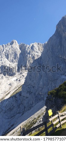 
view of the dachstein west in styria austria on a beautiful day in summer the picture was taken behind a wooden fence