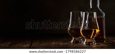 Scotch Whiskey without ice in glasses and bottle, rustic wood background, copy space banner  Royalty-Free Stock Photo #1798586227