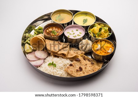 Maharashtrian food Thali or platter - Mumbai style Meal from Indian State Maharashtra includes, roti, rice, dal, sabji, sweet roti and rice, kadhi, Modak, papad etc Royalty-Free Stock Photo #1798598371