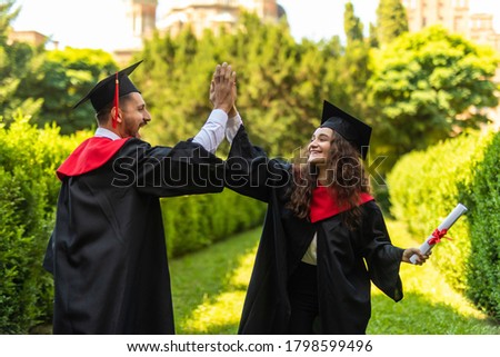 A graduates in the mantle embrace and enjoy. Beautiful graduate girl and boy enjoyed the ceremony graduation.