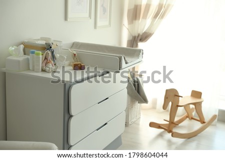 Modern changing table in baby room interior