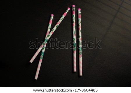 Four cute Unused Pencil on Black Background. With The shadow of light shining through the window.