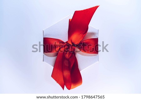 White gift box with a red ribbon isolated on white background. Christmas background with copy space. Birthday, Valentine's gift box.