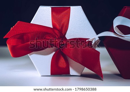 White and red gift boxes isolated on a black and white background. Christmas background with copy space. Birthday, Valentine's gift box.