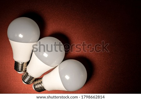 Several led light bulbs on dark red background with copy space.
