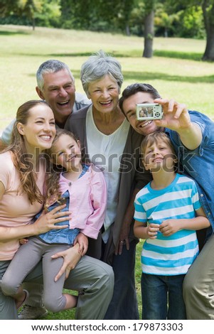 Man taking picture of his cheerful extended family at the park
