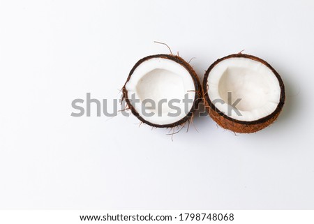 Two halves of raw coconut on a gray background. Healthy healthy food concept