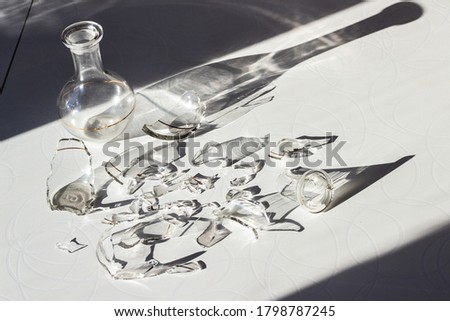 
whole and broken decanter on a white table