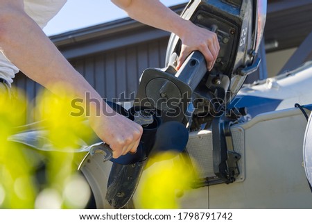 man changing propeller on outboard motor. Repairing outboard motor for boat, replacing screw. Royalty-Free Stock Photo #1798791742