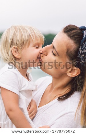 Mom kisses her daughter. Mothers Day. Family Concept