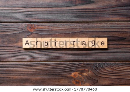 Arbitrage word written on wood block. Arbitrage text on cement table for your desing, concept. Royalty-Free Stock Photo #1798798468