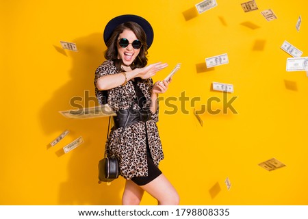 Photo of crazy positive girl spend waste hundred dollars credit bank earnings air fly money isolated over bright shine color background wear headwear skirt sunglass
