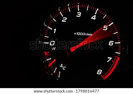 Instrument panel with tachometer and fuel level temperature engine, Close up image of illuminated car dashboard. Red arrow moving