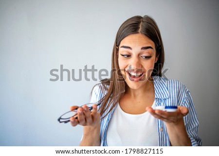 Woman holds out glasses and contact lenses. The choice between contact lenses and glasses.  Woman holds out glasses and contact lenses. Myopia and eyesight problem concept.