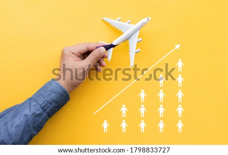 Business transportation or aviation with male hand holding mockup airplane and people tourist icon.Go to travel after covid 19 outbreak