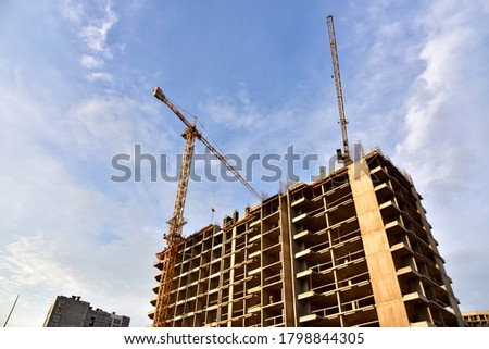 Tower cranes in action at construction site. Construction process of the new modern residential buildings. Road work and streets repair in city. Preparing to pour of concrete into formwork. Soft focus