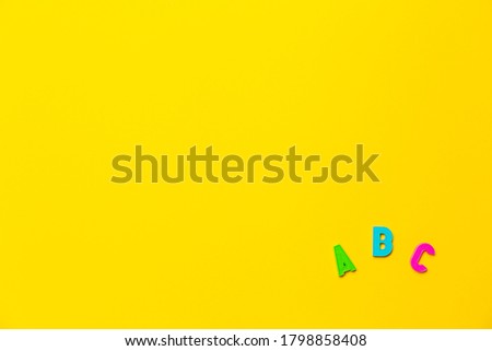 Multicolored letters A, B, C of the alphabet on a yellow background. Learning foreign language for beginners. Primary school education, grammar lesson. Banner on educational theme with free text space