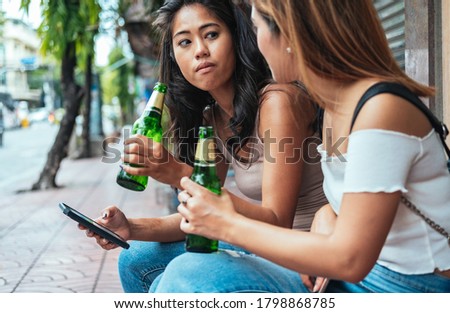 Two female friends drinking beer and having fun stock photo