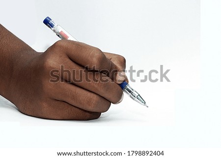 Hand holding pen writing on white background, closeup.