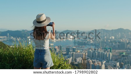 Woman use of cellphone to take photo under sunset