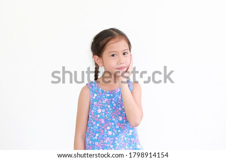 Portrait of asian little child girl touching hand on chin and cheek isolated on white background with looking at camera.