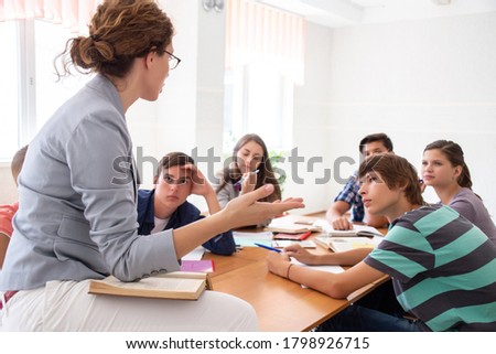group of students listening to the teacher in the classroom at school