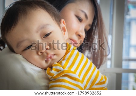 An Asian boy was crying in sorrow, being carry by his mother to calm down. The child cries because of illness causing discomfort. Royalty-Free Stock Photo #1798932652