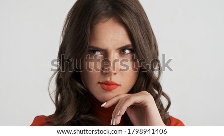 Close up attractive slyly brunette girl thoughtfully looking away over white background