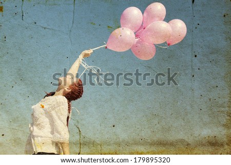 beautiful woman with colorful balloons outside. Photo in old image style.