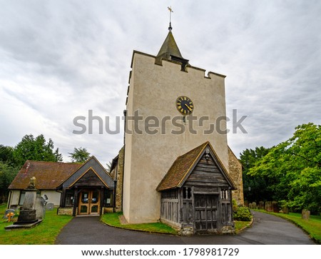 St Bartholomew's Church in Otford, Kent, UK. The church has a square tower with a clock and spire. The Church of St Bartholomew in Otford is a grade 1 listed building.