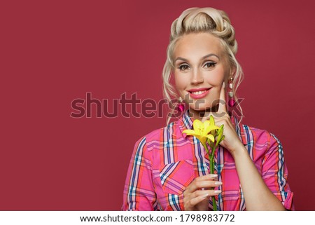 Cute pinup woman with vivid yellow flower. Pretty female model with red lips makeup and vintage fashion hairstyle
