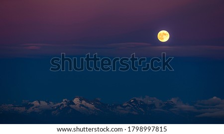 The full moon over the alpine moutains. Picture was taken on the summit Zugspitze, highest mountain in Germany. 