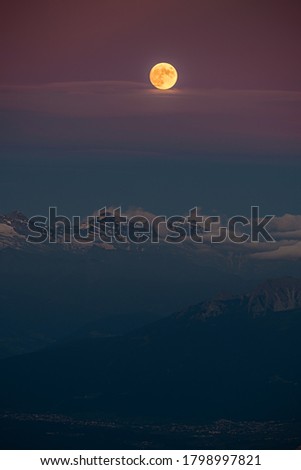 The full moon over the alpine moutains. Picture was taken on the summit Zugspitze, highest mountain in Germany. 
