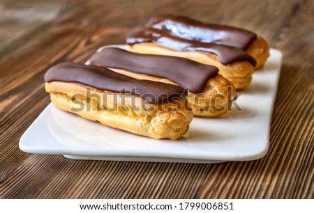 Eclairs with chocolate topping on serving plate Royalty-Free Stock Photo #1799006851