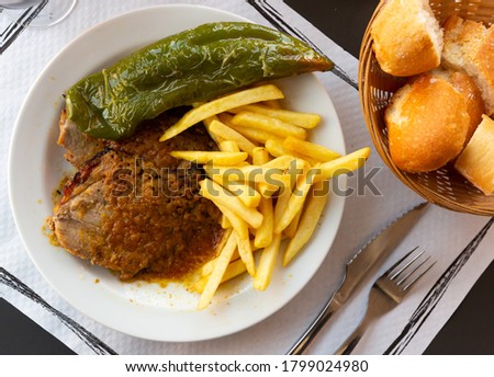 Close up of tasty fried pork with  french fries, served  on  plate